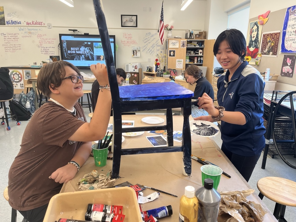 Walsh art club students painting a chair