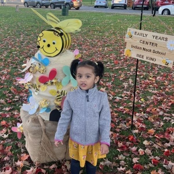 student posing with scarecrow