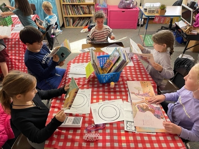 students sitting at a table with books